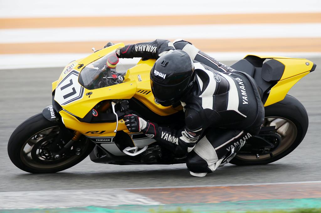 Motoqueiro pilotando uma moto amarela durante corrida