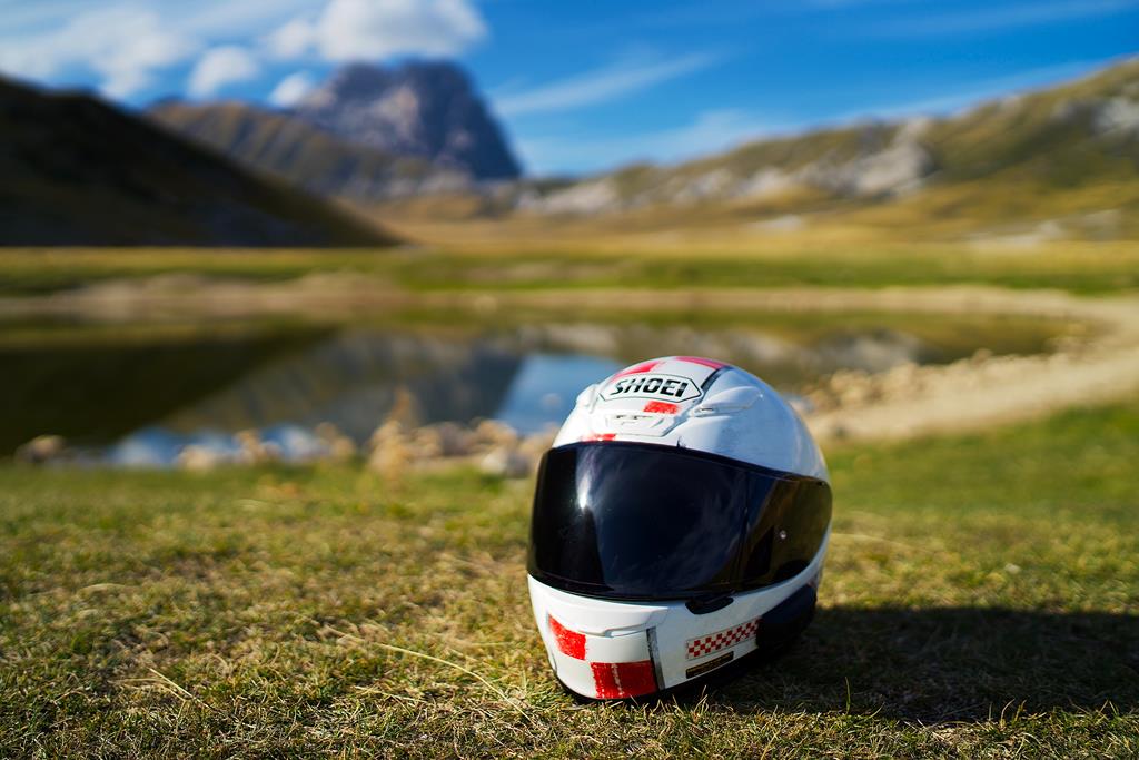 capacete branco com viseira preta em cima da grama