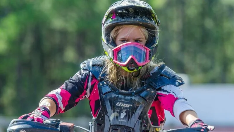 Motoqueira utilzando capacete de motocross e viseira branca