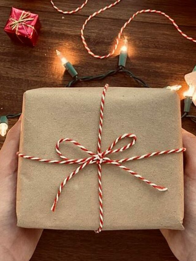 pessoa segurando um embrulho de presente perto de enfeites de natal