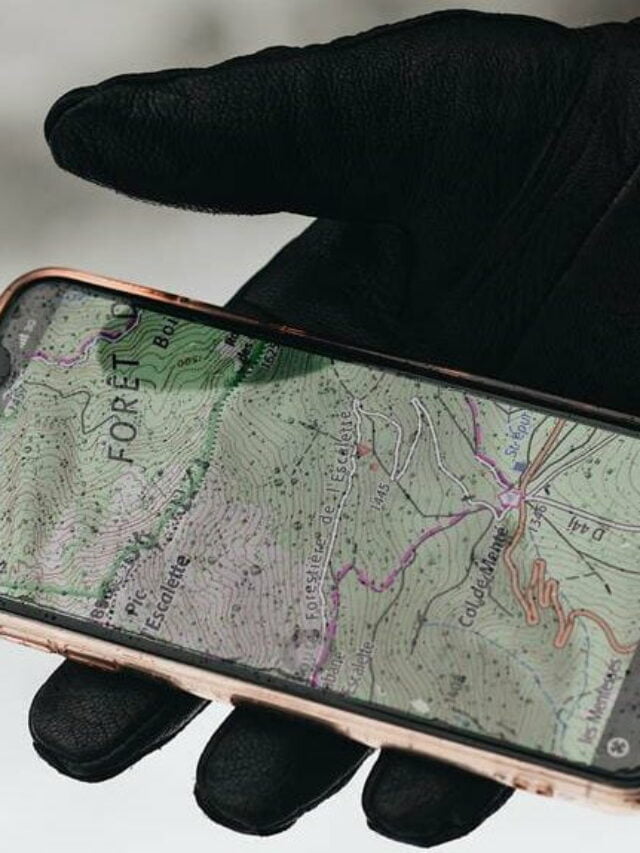 Pessoa usando luva preta segurando um celular